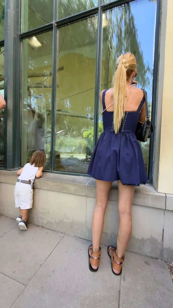 Nicole eligió un vestido corto azul marino con breteles finos y volados en el ruedo, que combinó con una cartera negra y su clásico cabello lacio, apostando por un look cómodo y elegante para recorrer la capital austríaca.