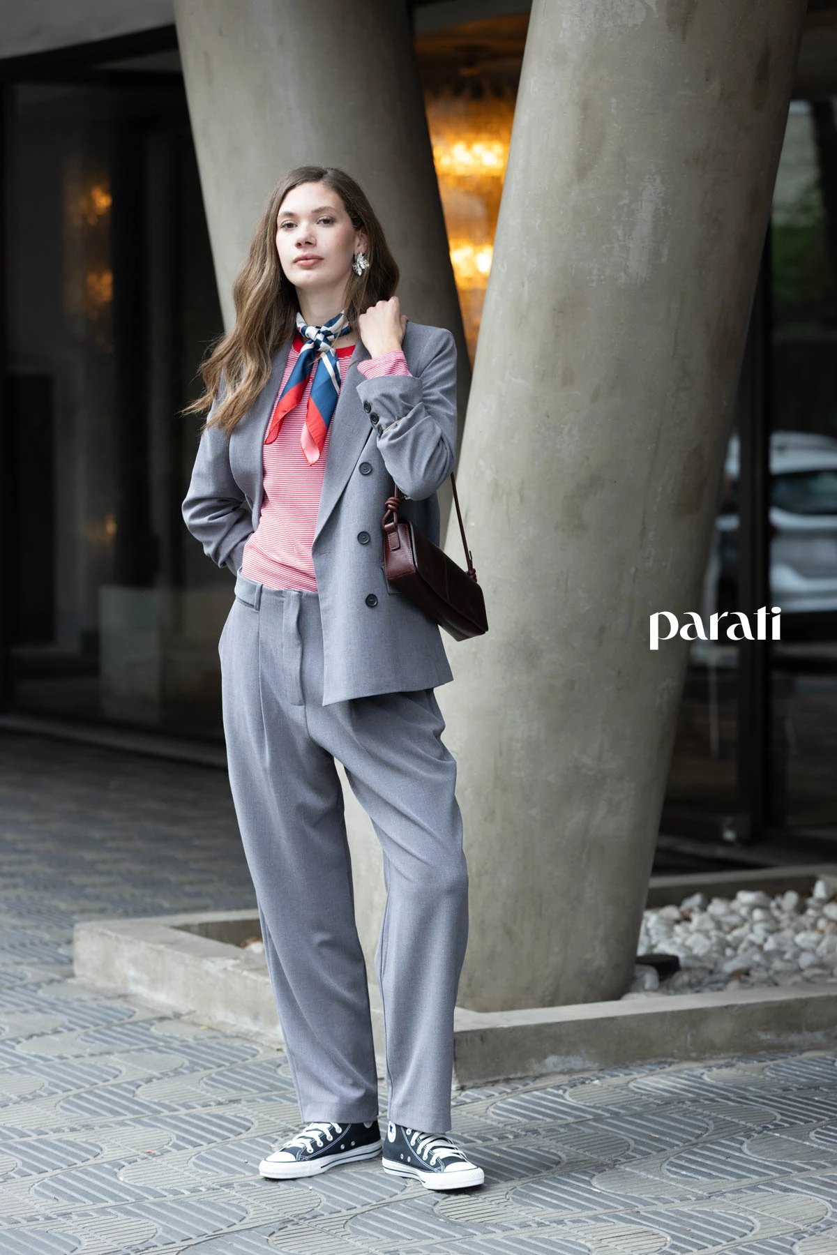 Traje de blazer cruzado y pantalón gris @claraibargurenoficial, remera manga larga rayada @boliviauniverso, zapatillas de lona negra @converse_ar, pañuelo combinado @perramusoficial, cartera de cuero bordó @mishkabuenosaires y aros flor plateados @ritace.accesorios