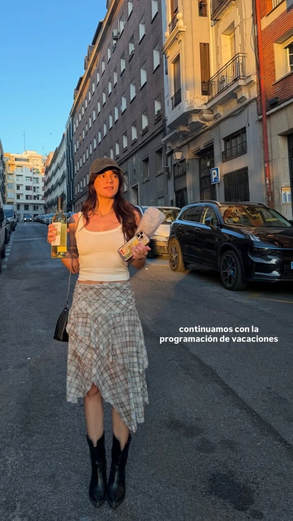 La gran protagonista del outfit fue una falda midi de cuadros en tonos grises con volados asimétricos que aportaron movimiento y un aire romántico a la silueta.
