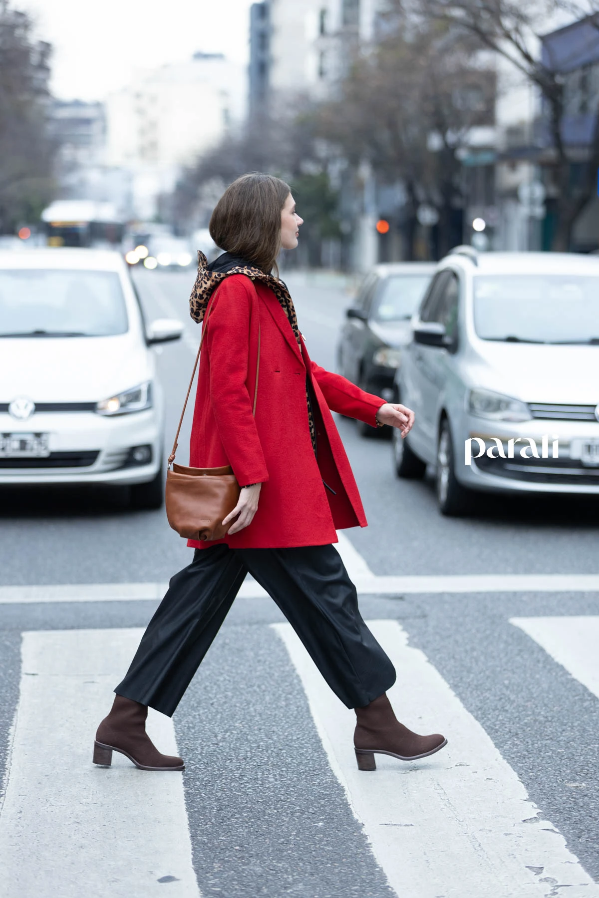Tapado de lana rojo, cruzado @perramusoficial, campera animal print @hunterbootsar, suéter polera de lana negra @boliviauniverso, pantalón de ecocuero negro @mishkabuenosaires, botas marrones capellada tejida @mishkabuenosaires. Mini bag de cuero marrón @mishkabuenosaires, aros gota dorados @ritace.accesorios y paraguas rojo @perramusoficial