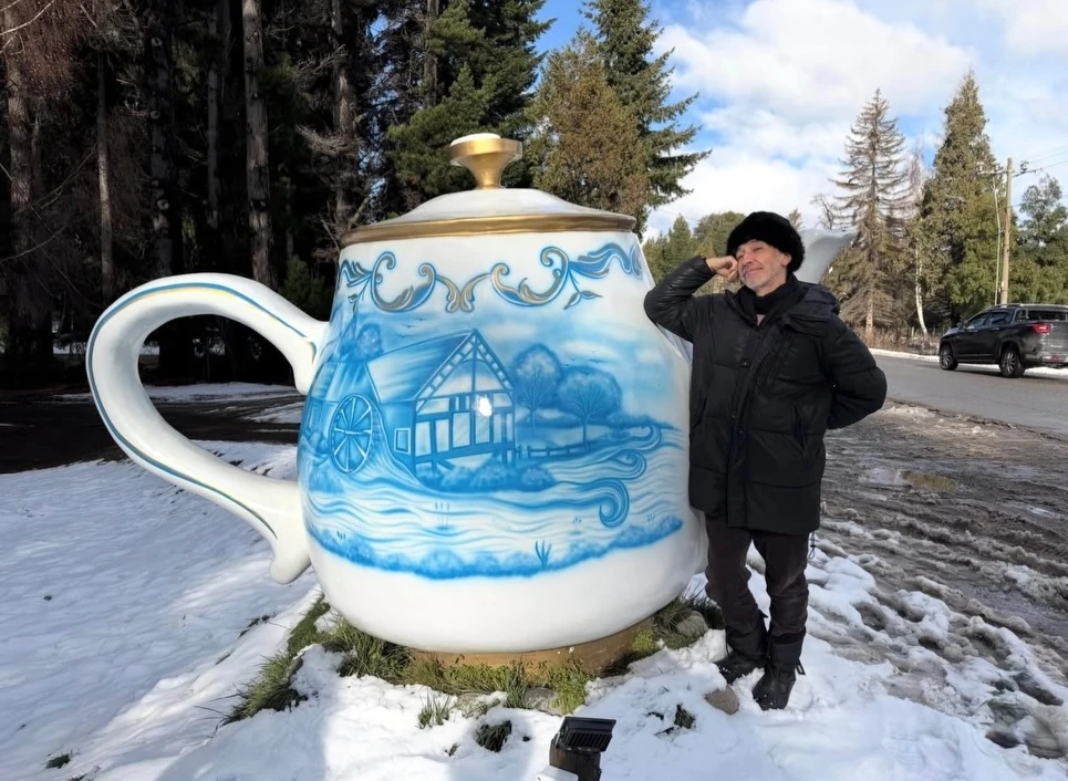 En una de las imágenes, Alejandro Ros posó junto a la tradicional tetera gigante de Villa La Angostura, una de las postales más curiosas de la escapada.