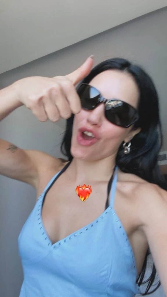 She wore a pastel blue halter-top with thin straps and a V-neck, with small studs in that area, a detail that gave the garment a distinctive touch.