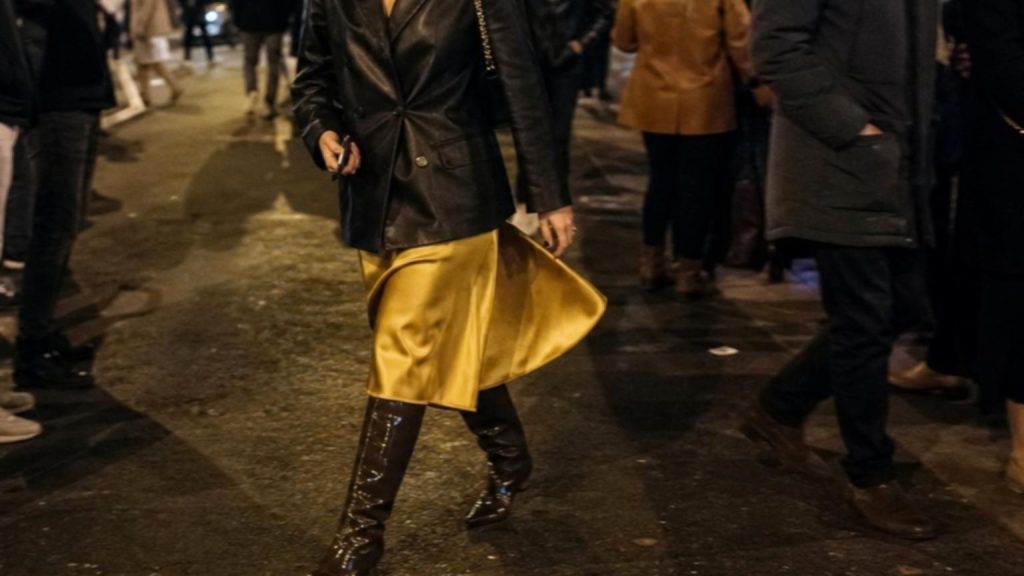 A woman struts confidently down a bustling city street, her glossy …